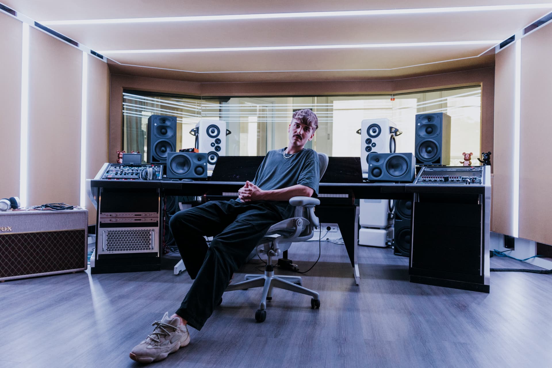 Mccoy seated at the console in a recording studio control room, with monitors, acoustic treatment and an LED-lit ceiling