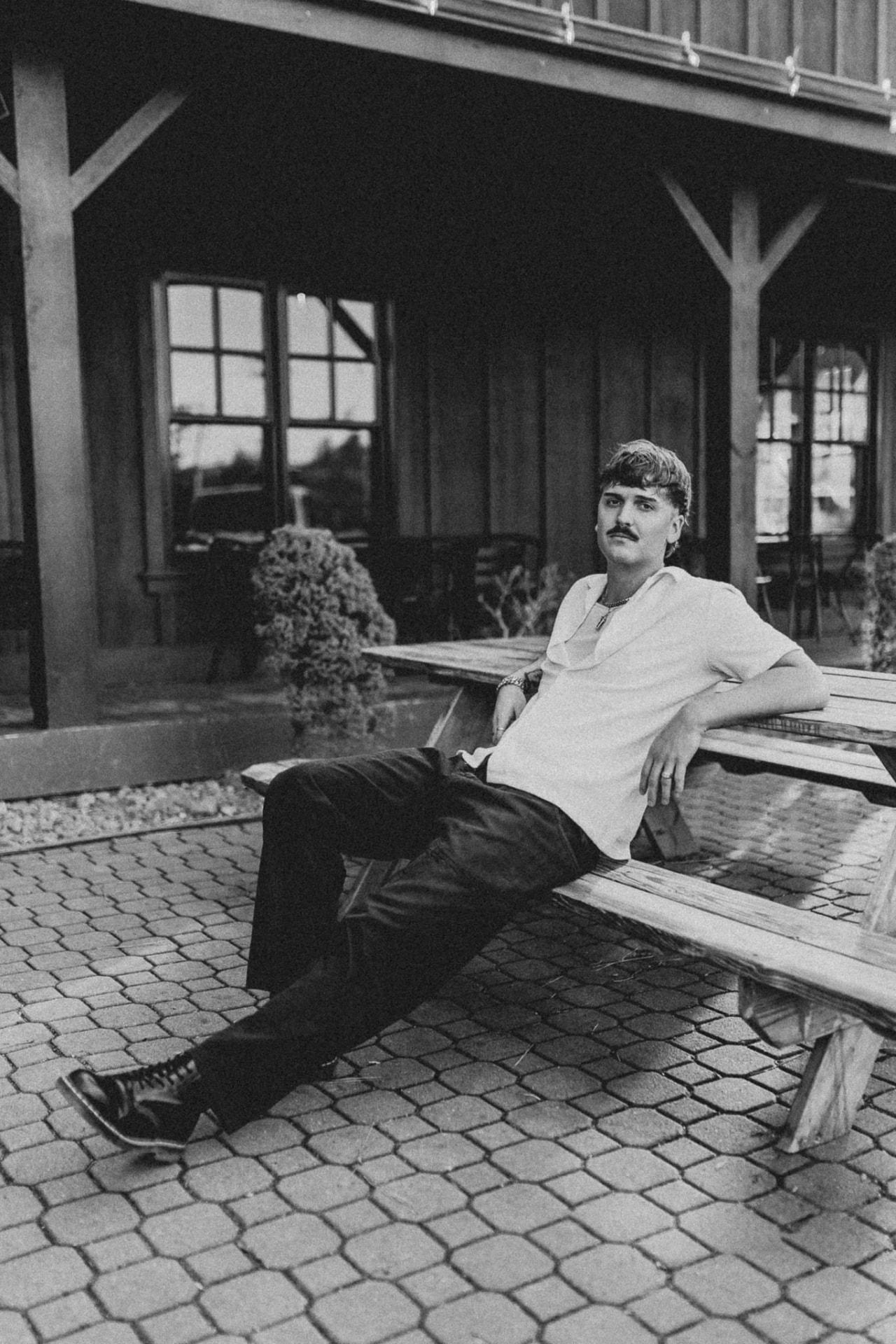 Mccoy — photographed in black and white, seated outdoors on a wooden bench
